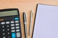 Calculator, two ballpoint pens and a notepad on a wooden table. CopyÃÂ Space Royalty Free Stock Photo